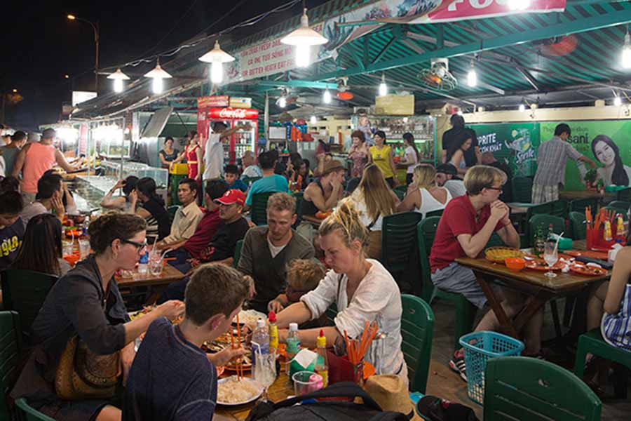 Vietnamese diners enjoying fast food at night market